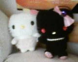 2 hello kitty plushes, one is white and the other is black