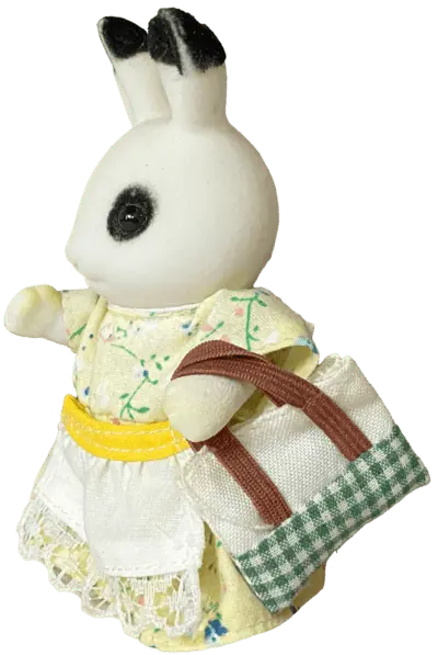 a sylvanian families black and white rabbit in a yellow dress