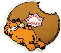 garfield reclining on a donut, in the middle of the hole it says stuffed again